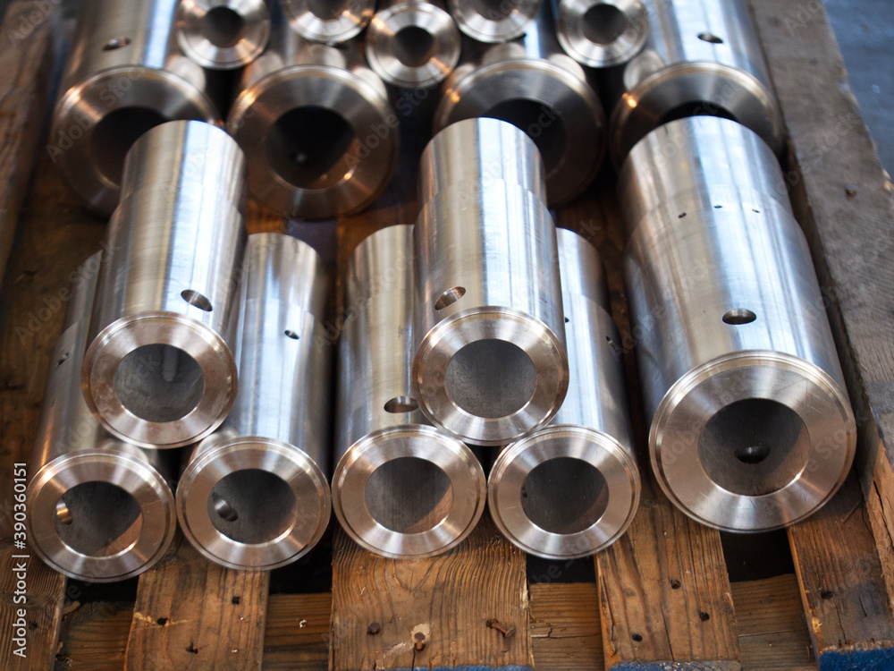 Naklejka premium Elementy toczone ze stali nierdzewnej jako półprodukty na paletach w zakładzie produkcyjnym