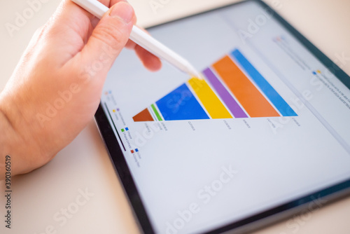 Sales marketing funnel showed on a tablet screen by a young marketer, sales manager pointing data with his pen.
