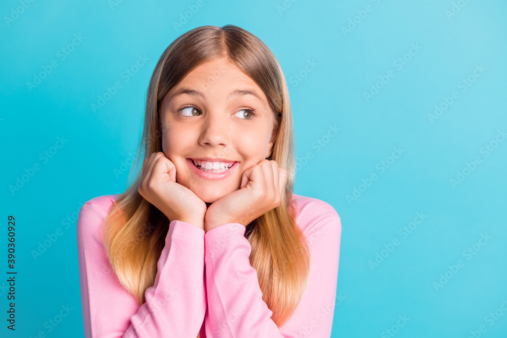 Fototapeta premium Photo portrait of dreamy schoolgirl with blonde hair smiling touching cheekbones with hands isolated on vibrant turquoise color background
