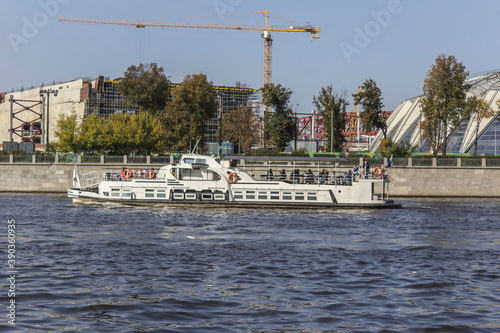 A double-deck pleasure ship sails along the river.Mid-twentieth century design. Photo for the site about tourism, travel, boat trip, rivers and lakes.
