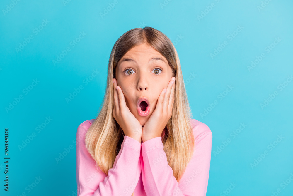 Photo portrait of schoolgirl with blonde hair shouting touching cheeks amazed shocked isolated on bright teal color background Photo portrait of schoolgirl with blonde hair shouting touching cheeks amazed shocked isolated on bright teal color background