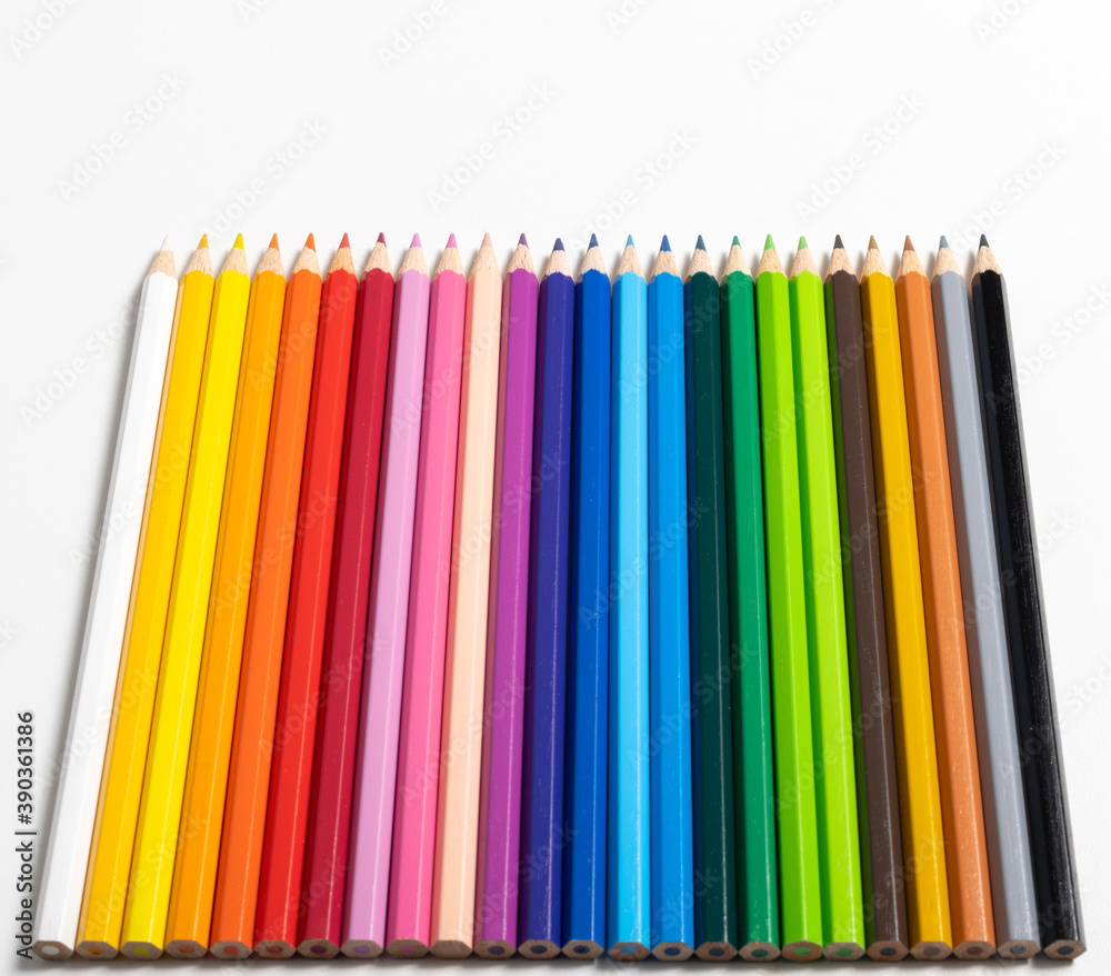 Buntstifte in verschiedene Farben aufgereiht auf weißen Hintergrund Buntstifte in verschiedene Farben aufgereiht auf weißen Hintergrund
