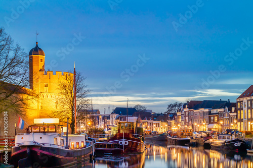 Dutch canal with sailing boats and stronghold tower in the city center of Zwolle photo