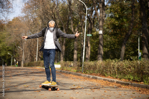 Happy man enjoying skateboarding outdoors during pandemic