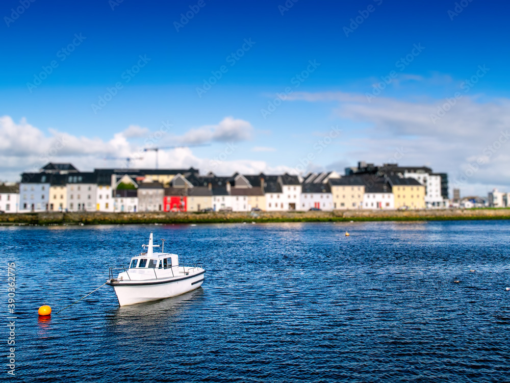 Small boat in Corrib river, Galway city, Ireland. Warm sunny day. Nobody. Blue water and sky