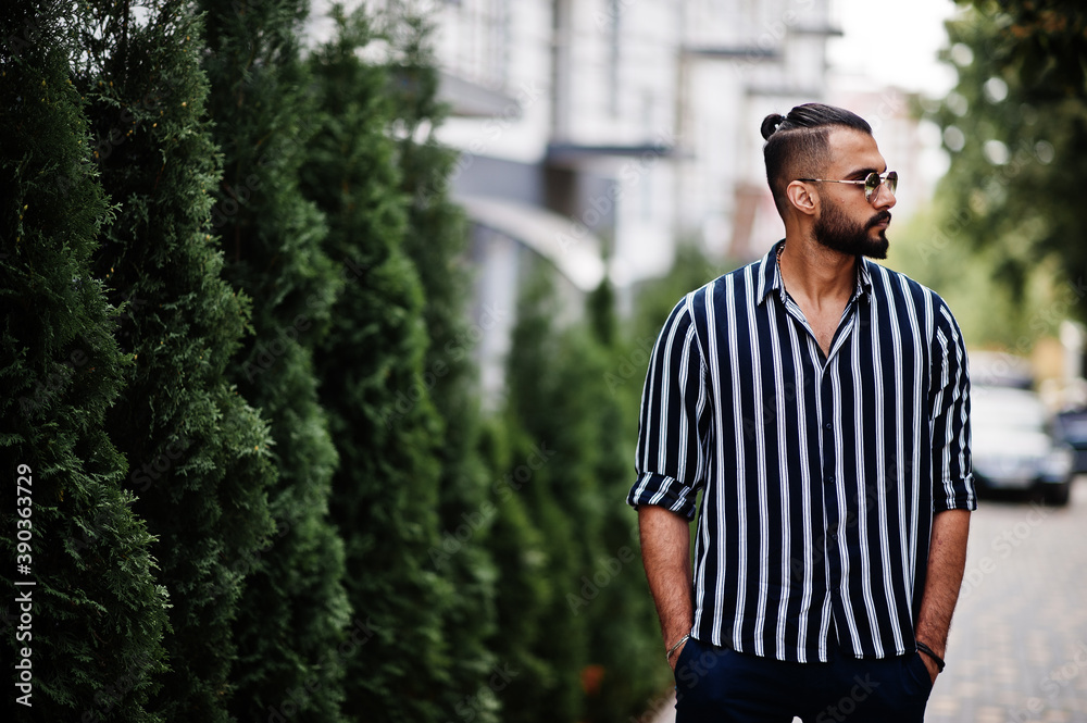 Successful arab man wear in striped shirt and sunglasses pose outdoor. Successful arab man wear in striped shirt and sunglasses pose outdoor.