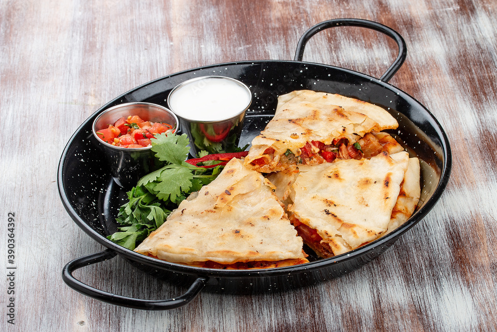 Quesadilla with pork, cheese and paprika. In a metal frying pan. Traditional Mexican dish Quesadilla with pork, cheese and paprika. In a metal frying pan. Traditional Mexican dish