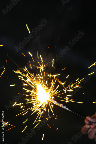 A burning sparkler pencil on black background