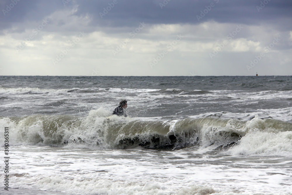 surfer in der nordsee bei stürmischem wetter