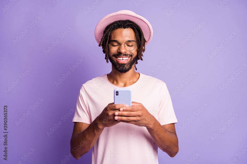 Photo portrait of man holding phone in two hands typing isolated on vivid purple colored background Photo portrait of man holding phone in two hands typing isolated on vivid purple colored background