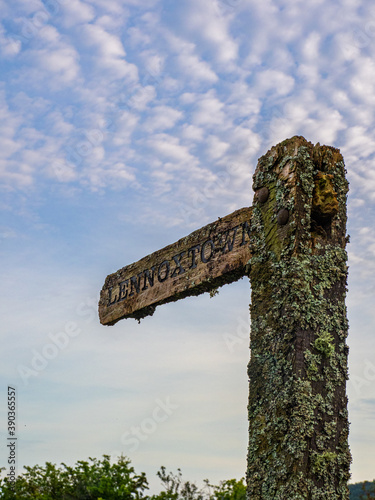 The wooden signpost showing the direction on the footpath to Lennoxtown, Scotland photo