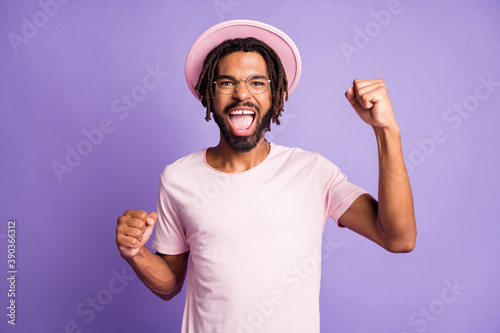 Photo portrait of excited man celebrating victory isolated on vivid purple colored background
