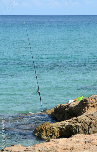 a fisherman on the rocks with his fishing rod