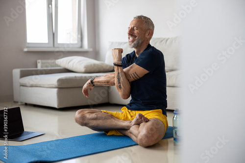 Fotografija Smiling sportsman laying one arm on another