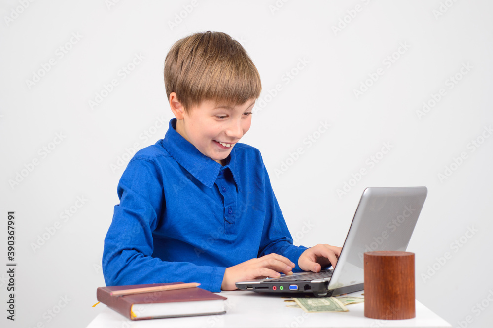 little businessman - Young smart pretty boy looks. Notepad and Notepad are on the table little businessman - Young smart pretty boy looks. Notepad and Notepad are on the table
