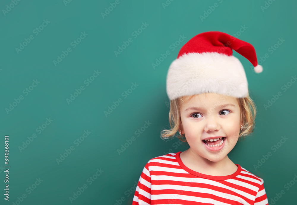 Child in santa hat empty space background.Kid in christmas costume closeup portrait.