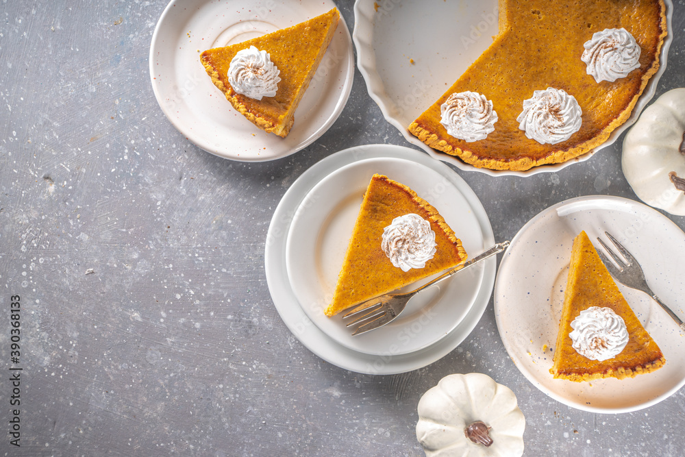 Traditional Autumn Pumpkin Pie. Homemade American Pumpkin pie topped with Whipped Cream. Rustic wooden table bakcground with Cozy plaid and sweater. Traditional Autumn Pumpkin Pie. Homemade American Pumpkin pie topped with Whipped Cream. Rustic wooden table bakcground with Cozy plaid and sweater.