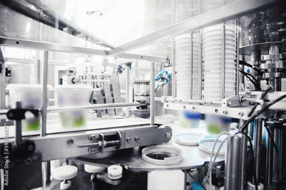 Automated filling of yoghurt into packages. Food production, dairy plant Automated filling of yoghurt into packages. Food production, dairy plant