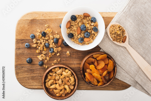 Fototapeta Naklejka Na Ścianę i Meble -  top view of delicious granola with nuts, blueberry and dried apricots isolated on white