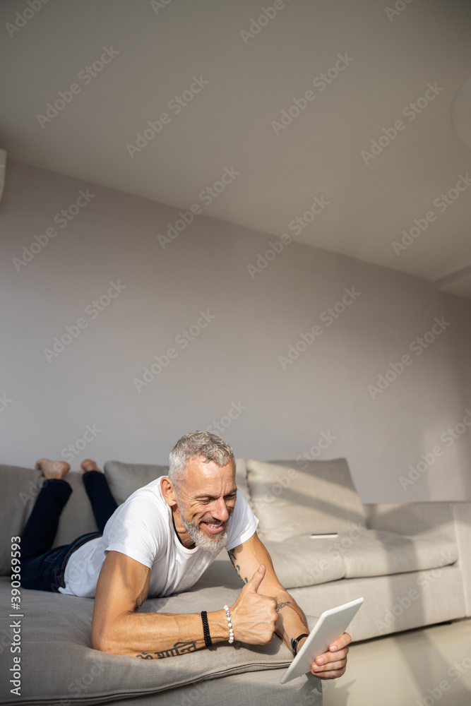 Caucasian male giving thumbs-up to the tablet camera Caucasian male giving thumbs-up to the tablet camera