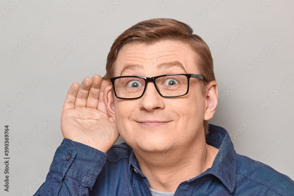 Portrait of happy man placing hand near ear and eavesdropping Portrait of happy man placing hand near ear and eavesdropping