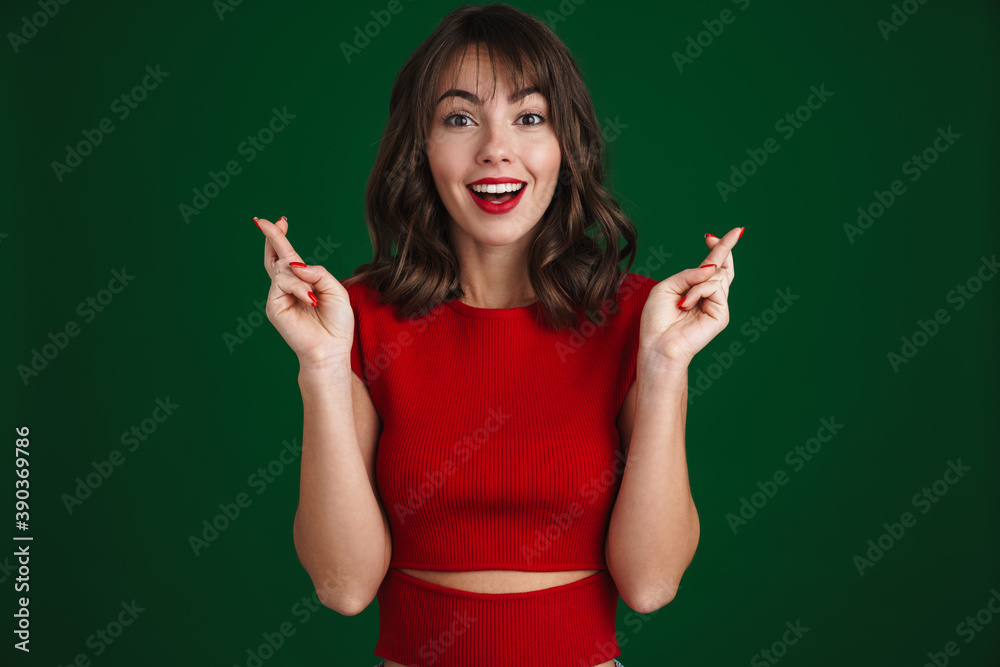 Happy girl smiling while posing with fingers crossed for good luck Happy girl smiling while posing with fingers crossed for good luck