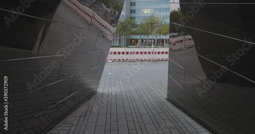 view through a reflective work of art through which you can see the tram in germany düsseldorf 4k photo
