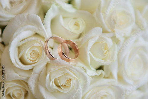 Gold wedding rings lie on the bouquet for the bride. Wedding rings in a rose. Wedding accessories