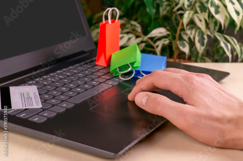online shopping concept. little deliver boxes, smartphone, shopping bags, shopping bascket stand on laptop. copy space