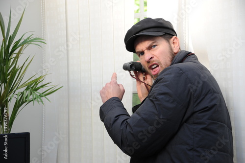 Obnoxious nosy sneeky neighbour peeking through the window photo