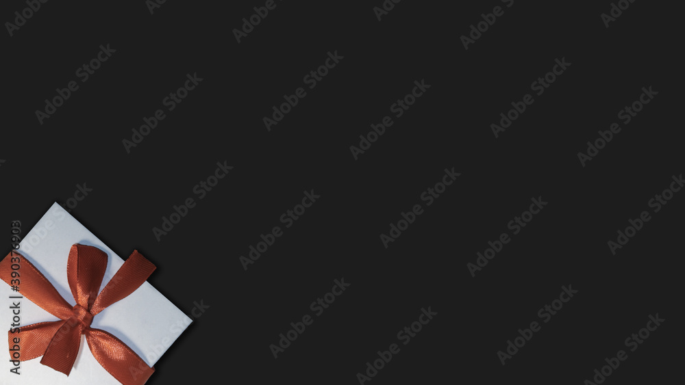 Gift with a red ribbon on a black background. Gift with a red ribbon on a black background.