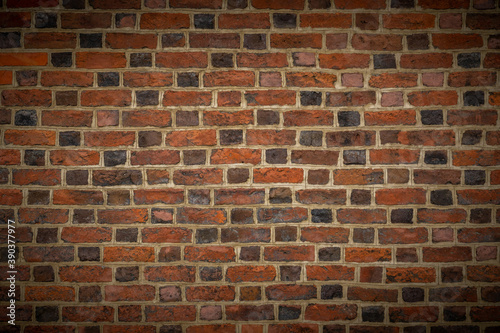brick wall with several shades of brown with vignetting. wallpaper, background