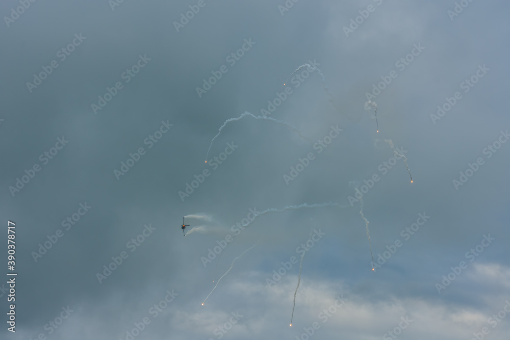 fighter plane at a air show with rain clouds with lot of defense measures