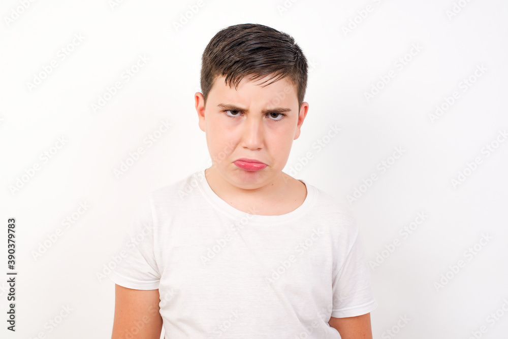 Caucasian young boy standing against white background crying desperate and depressed with tears on his eyes suffering pain and depression. Sad facial expression and emotion concept. Caucasian young boy standing against white background crying desperate and depressed with tears on his eyes suffering pain and depression. Sad facial expression and emotion concept.