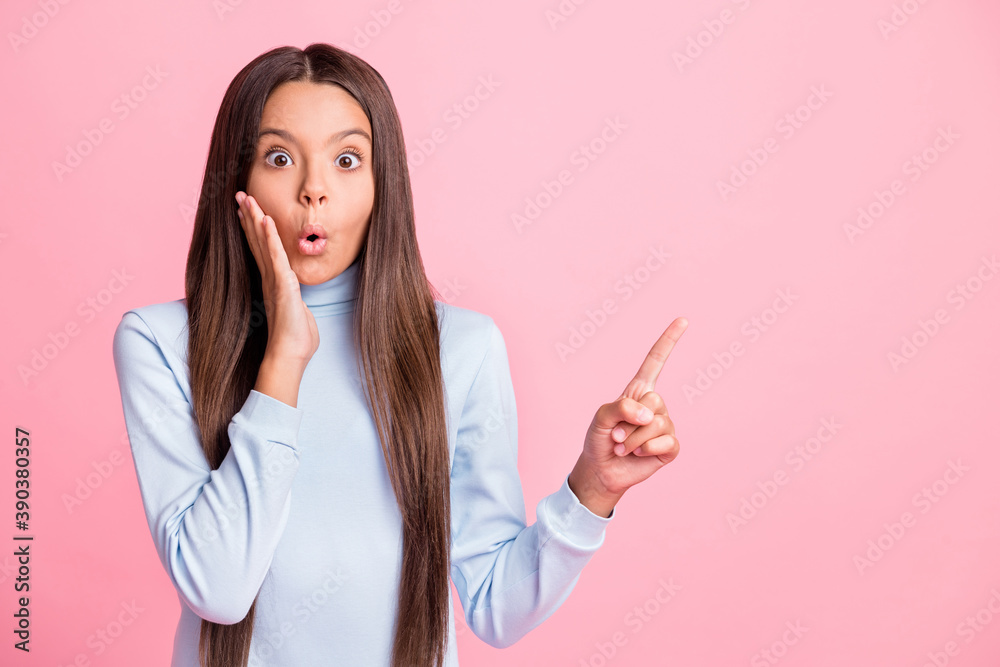 Portrait of school girl shocked hand on cheek indicate finger empty space isolated on pink color background Portrait of school girl shocked hand on cheek indicate finger empty space isolated on pink color background