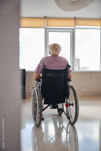 Disabled Caucasian man looking through the window