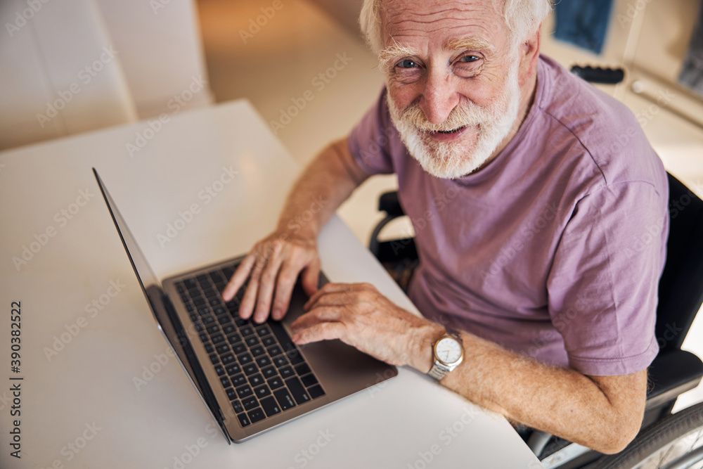 Contented modern pensioner posing with his gadget Contented modern pensioner posing with his gadget