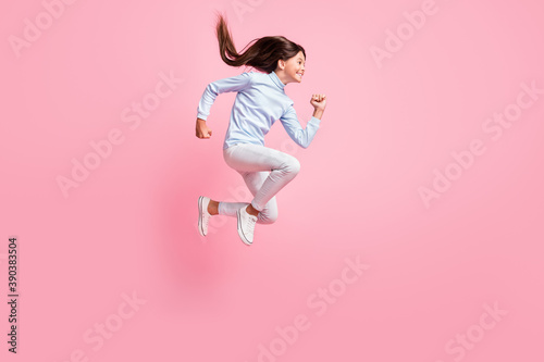 Full length body size view of pretty motivated cheerful girl jumping running fast speed energy isolated over pink color background