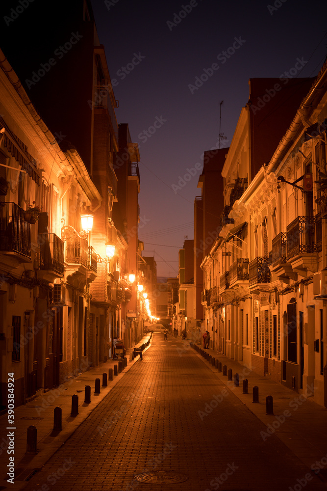 Empty narrow street with lights, at night