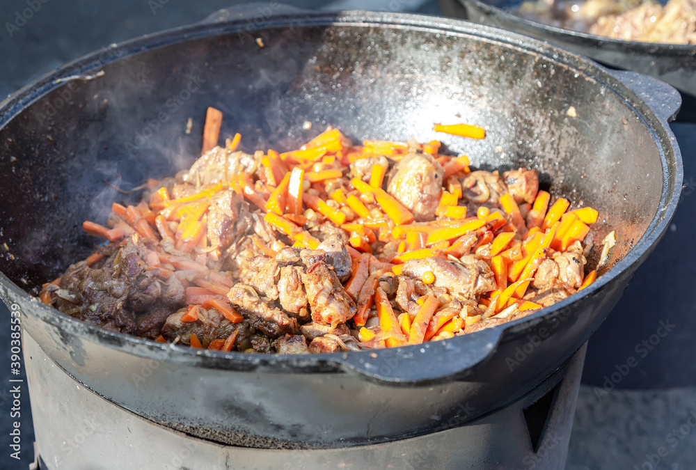 Cooking appetizing pieces of meat in a large cauldron Cooking appetizing pieces of meat in a large cauldron