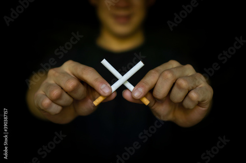 Hands of a young man who crosses cigarettes as a reminder to quit smoking  World No Tobacco Day Concept