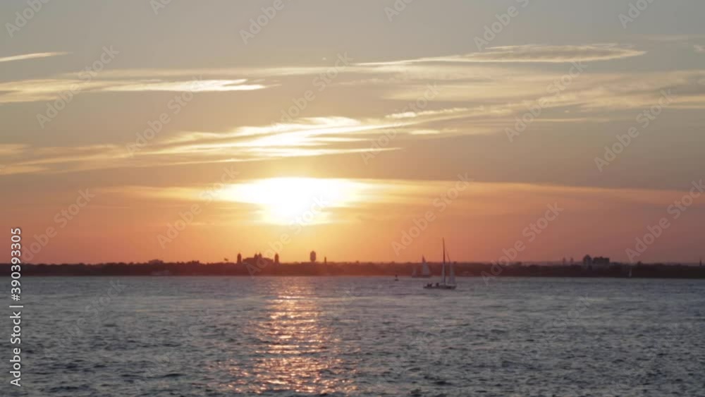 Sailboats Move Across Ocean Water During a Golden Sunset Sailboats Move Across Ocean Water During a Golden Sunset