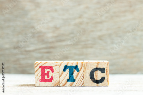 Alphabet letter in word etc (abbreviation of et cetera) on wood background photo