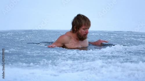 Winter swim. Young man with beard swims in a winter lake. Scene 1, camera 2 photo