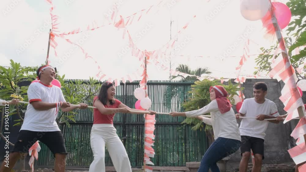 three people in one team tried to pull the rope hard during the tug-of-war competition at Indonesia's Independence Day celebrations