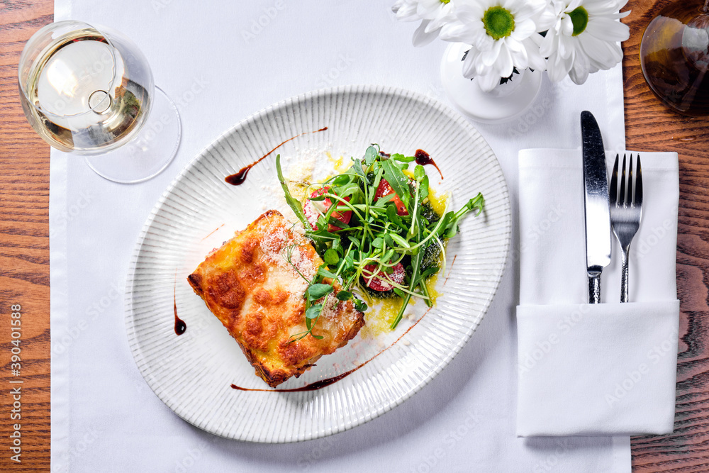 Lasagne bolognese in a plate on a table. Lasagne bolognese in a plate on a table.