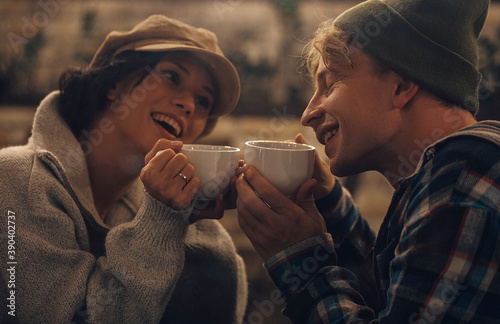 Happy young couple is drinking coffee and smiling while sitting at the cafe. Couple in love. Sensual. Coffee time. Background. People. 
