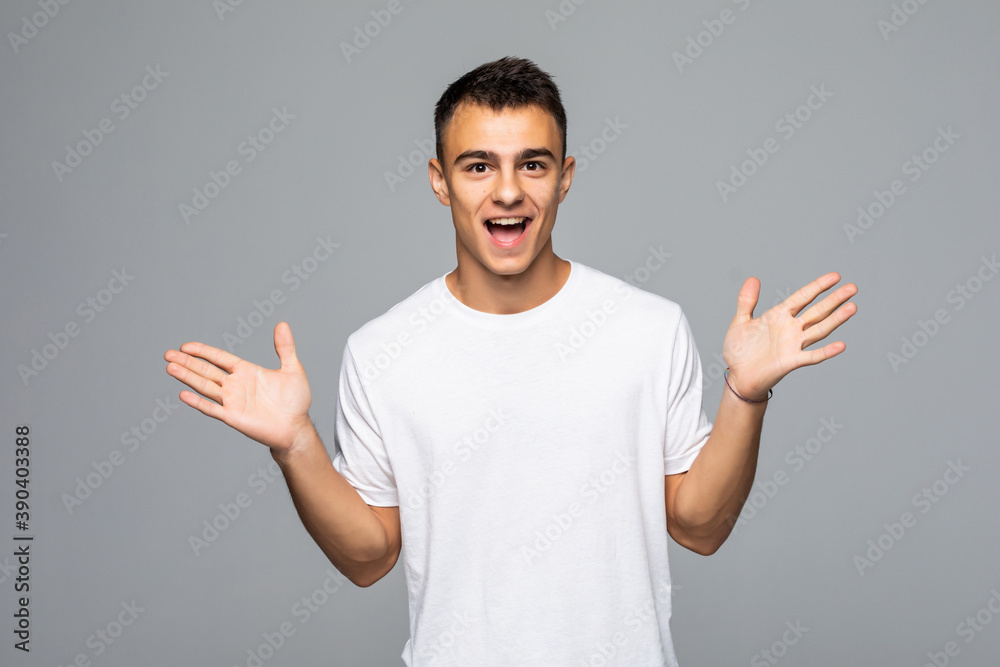 Portrait of a young surprised man with opened mouth isolated on gray background. Portrait of a young surprised man with opened mouth isolated on gray background.