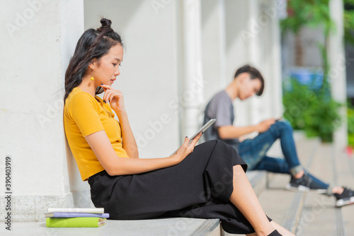 Online remote work Asian young woman on social distancing meeting remotly for work conference using tablet outdoor. © shine