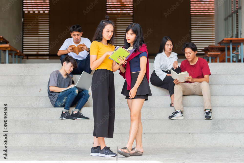 Obraz premium Group of young people are studying together in university. Students outdoors sitting on the stairs together.